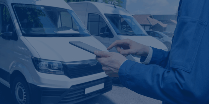 a person holding a phone in front of a van