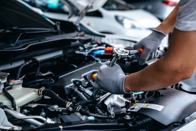 Mechanic,Using,Wrench,While,Working,On,Car,Engine,At,Garage Mechanic,Using,Wrench,While,Working,On,Car,Engine,At,Garage